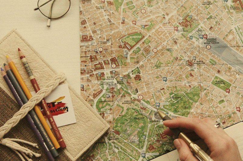 Mapa de cidade com lápis e caderno, durante o planejamento de uma viagem