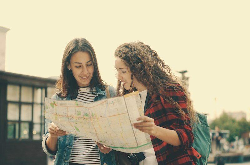 Duas amigas consultando um mapa na rua