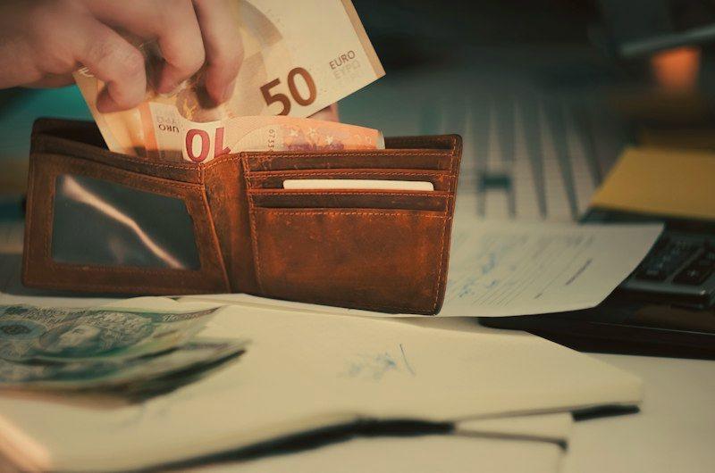 Notas de euro sendo guardadas na carteira